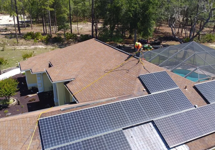 A man is cleaning the roof of a house